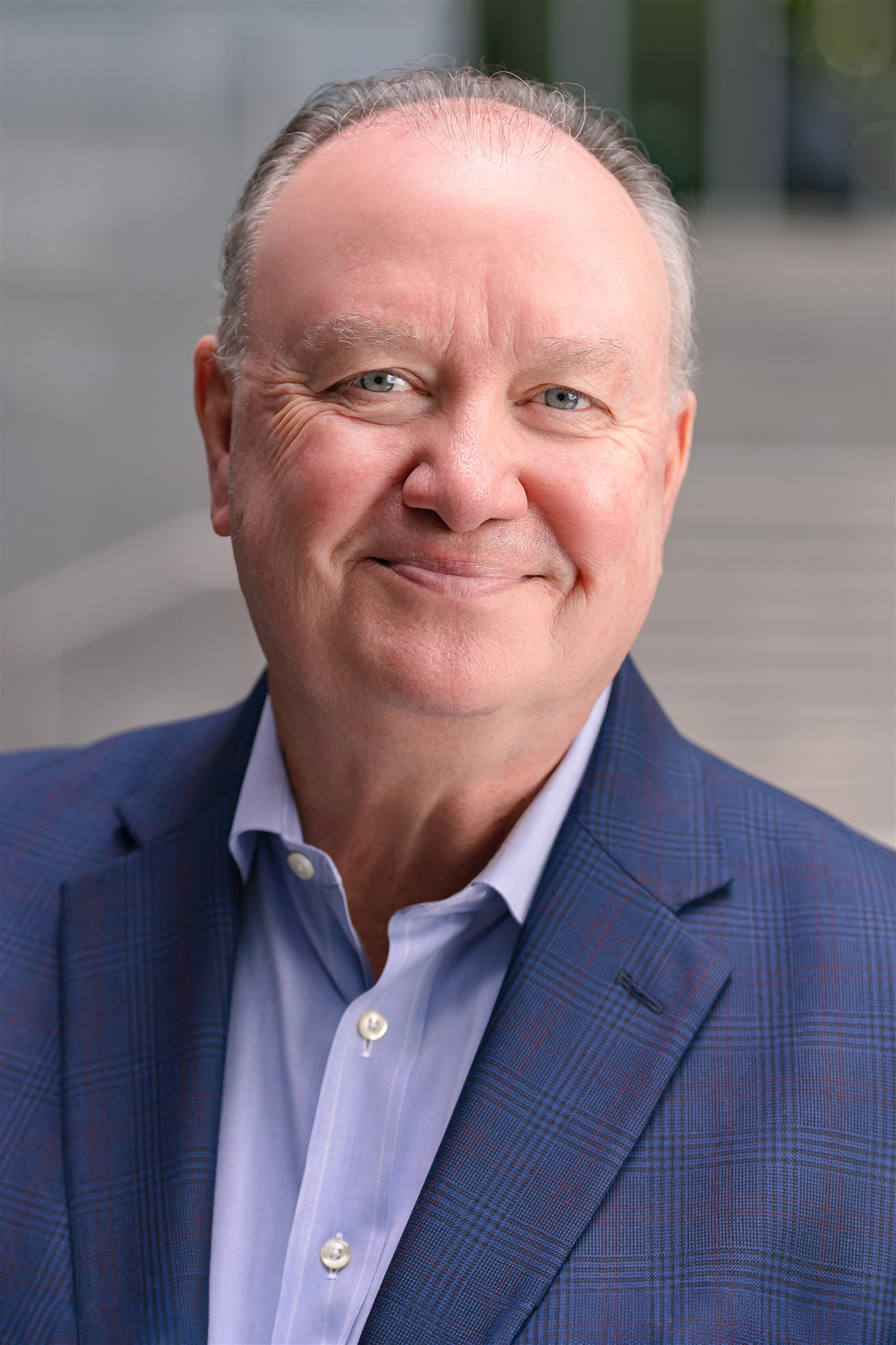 Headshot of Mike, who is wearing a blue suit