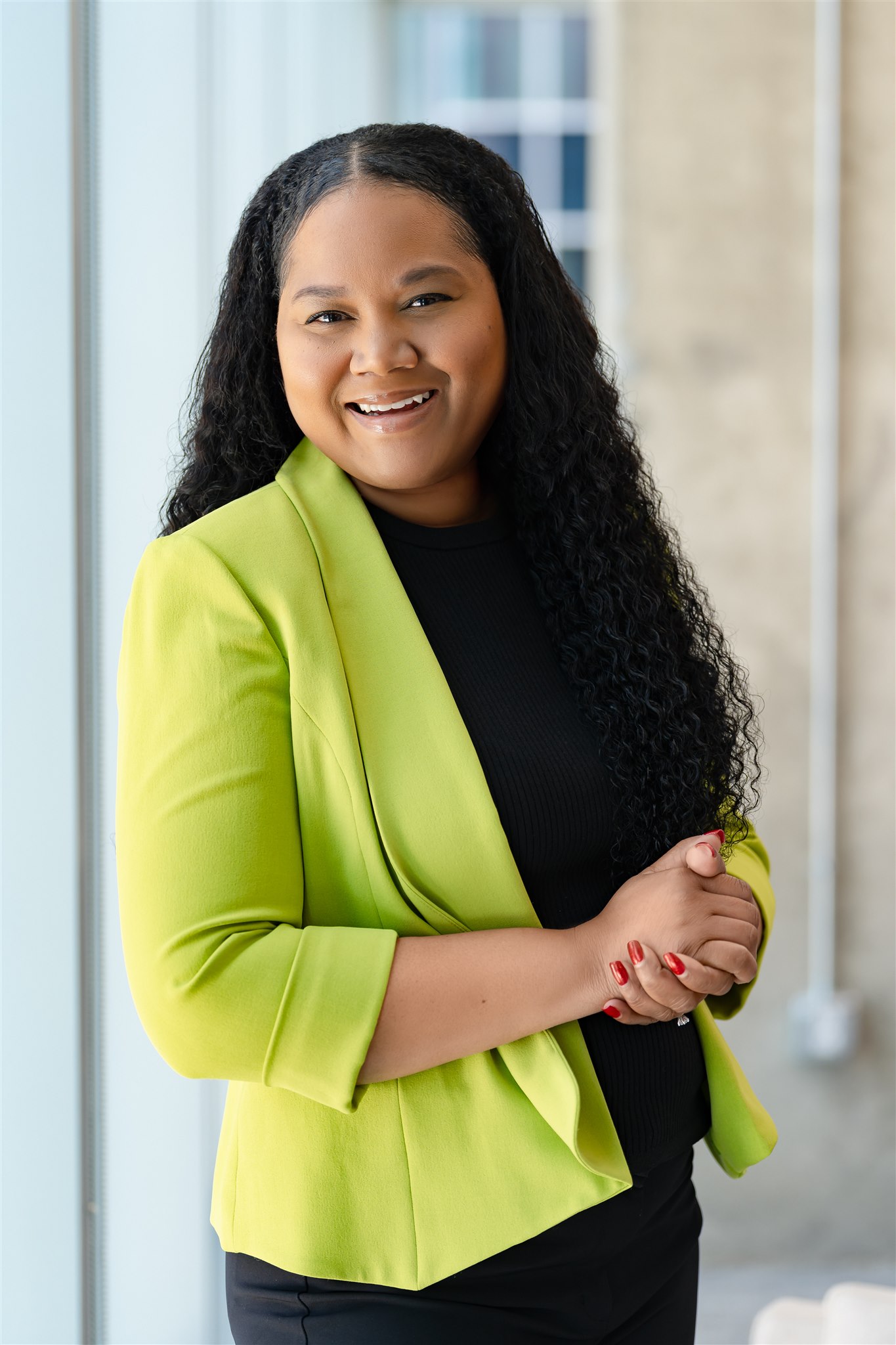 Headshot of Khym Preston who is wearing a lime green blazer